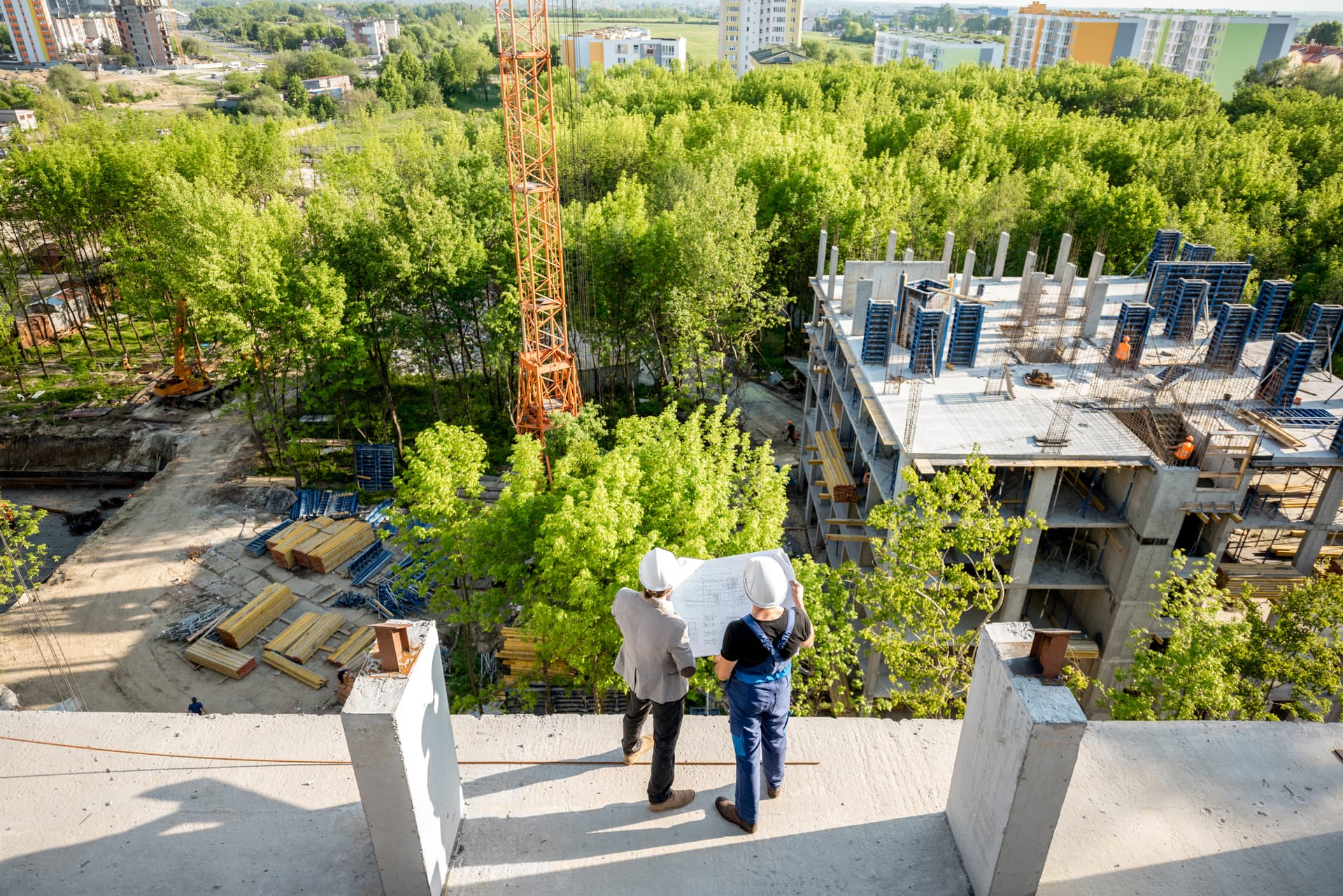 Aerial view of a construction site with workers reviewing plans